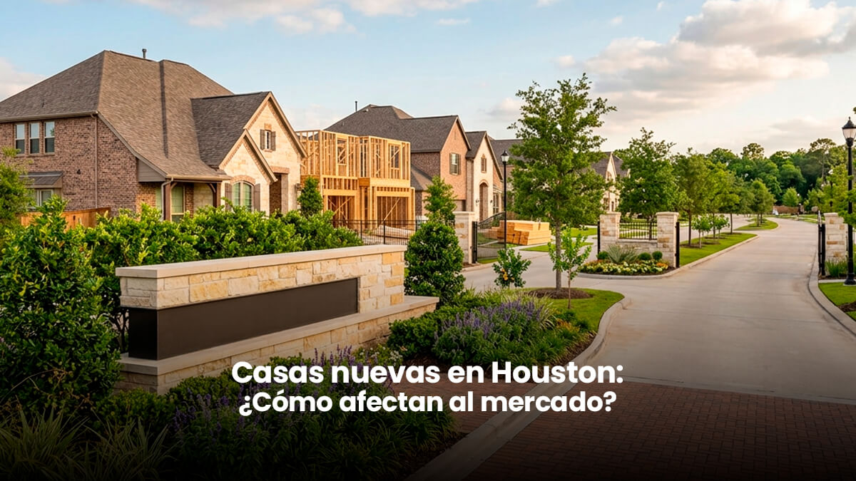 A modern gated master-planned community entrance in Houston, Texas, featuring pristine landscaping, brick pavement, natural stone monuments, new construction homes, and a street leading to a neighborhood under warm afternoon light, suitable for a real estate blog post.